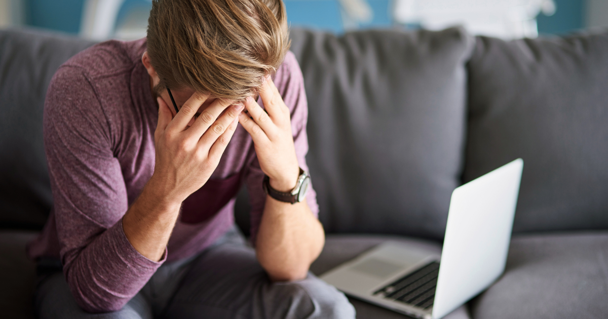 anxious man holding head in hands