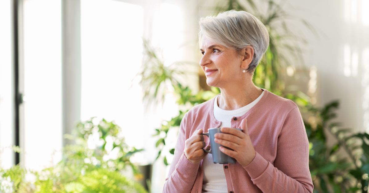 content older woman holding coffee mug