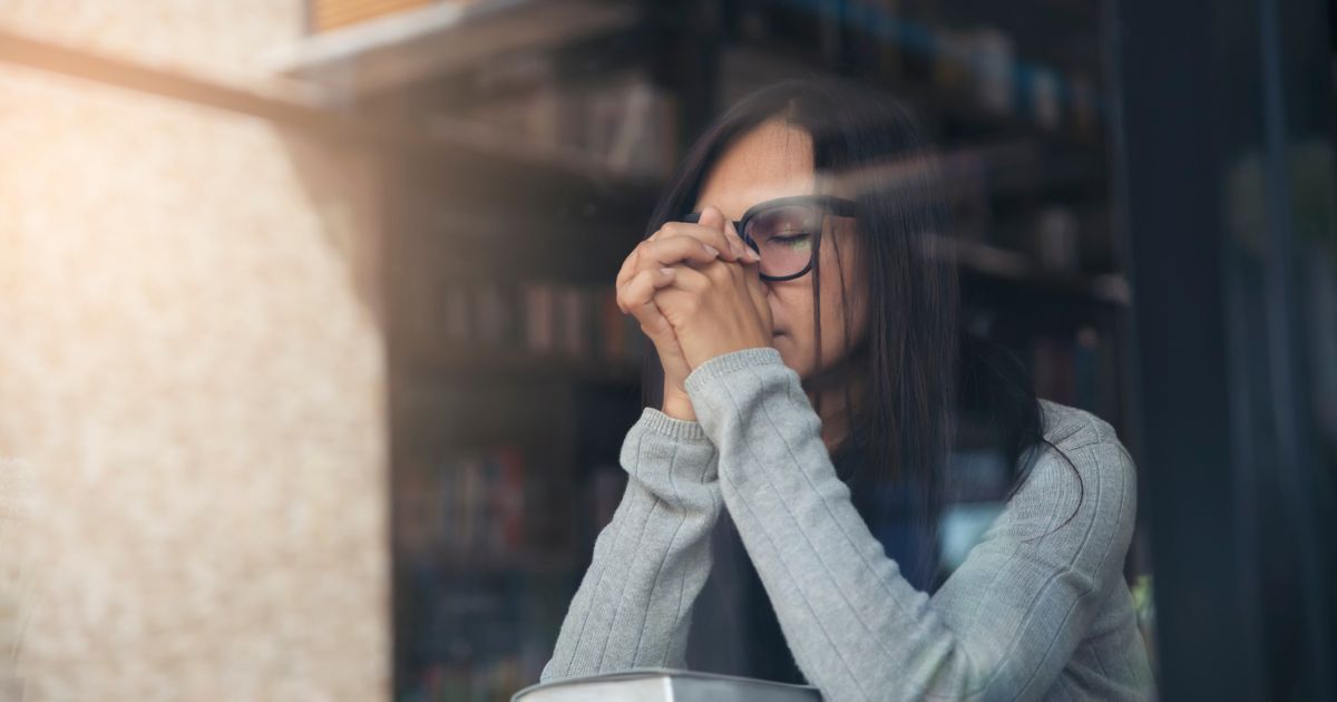 sad woman praying over Bible